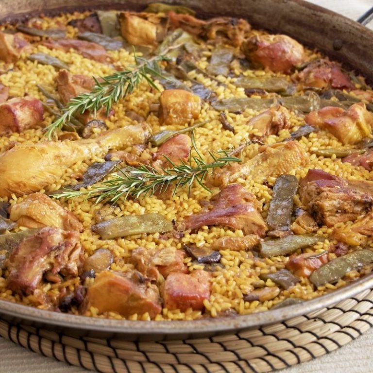 Paella valenciana de pollo y con conejo con verduras y romero