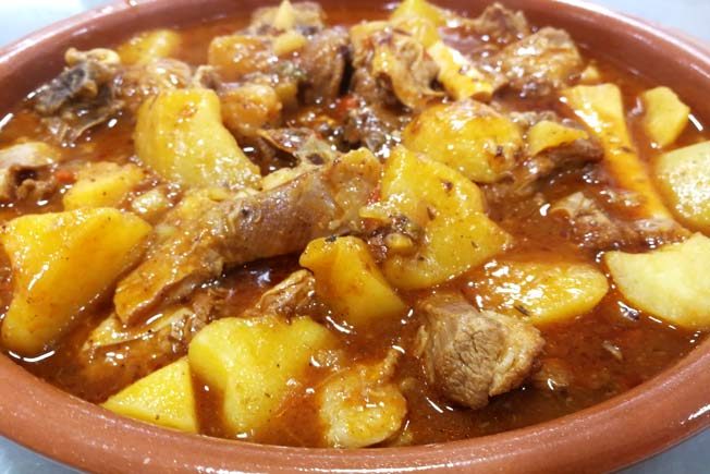 Guiso de carne con patatas en una cazuela de barro.