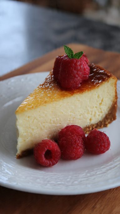 Trozos de tarta de queso Trozos de tarta de queso con frambuesas encima y alrededor.