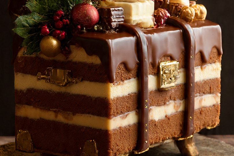 Tarta decorada como un maletín, con chocolate, frutas y adornos navideños.
